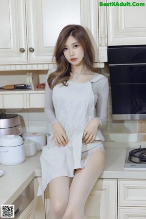 a woman sitting on top of a kitchen counter next to a stove