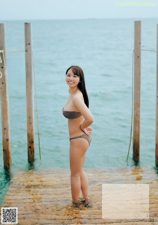 A woman in a bikini standing in the water.