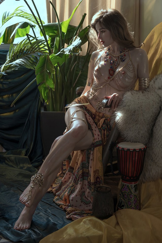 A woman sitting on a bed next to a drum.