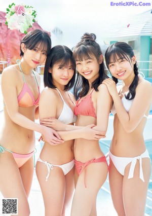 A group of three young women sitting on top of a railing.