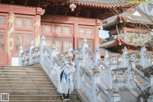 A woman in a white dress holding an umbrella.