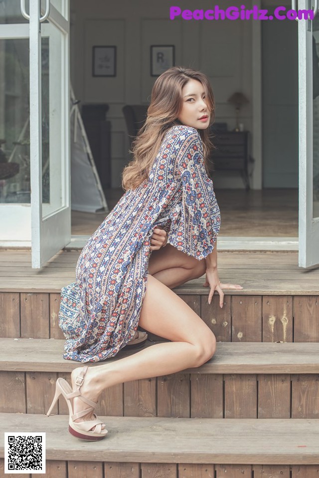 A woman sitting on the steps of a house.