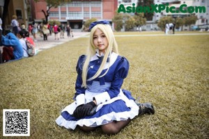 A woman with long blue hair sitting on a toilet.