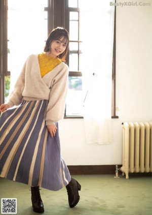 A woman in a white sweater is looking at the camera.