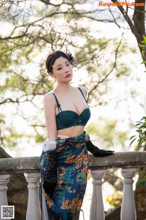 A woman in a green lingerie posing on a balcony.