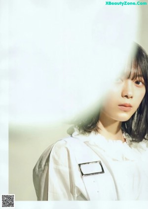 A woman standing in front of a wall of white circles.