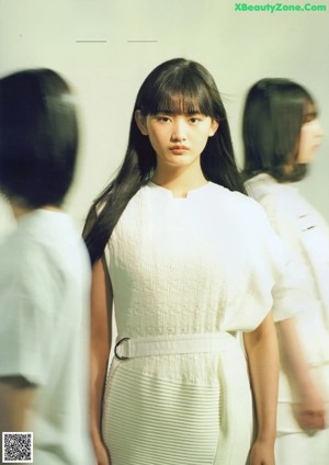 A woman standing in front of a wall of white circles.