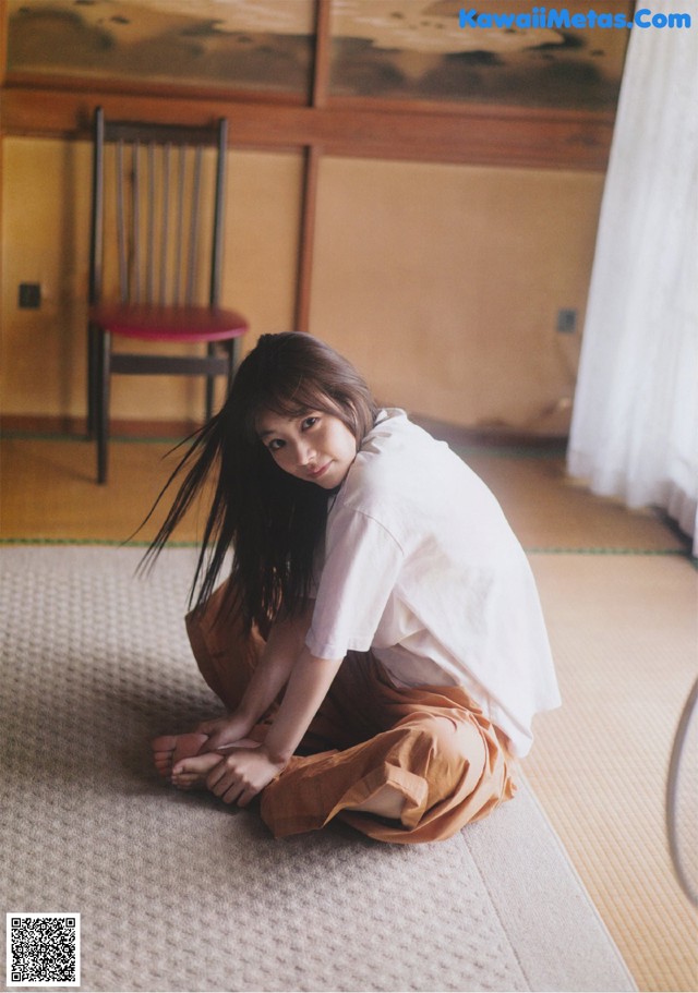 A woman sitting on the floor in a room.