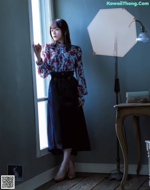 A woman in a purple shirt is posing for a magazine.