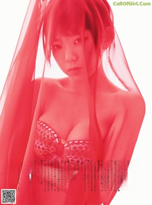 A woman in a red bikini sitting on the ground.