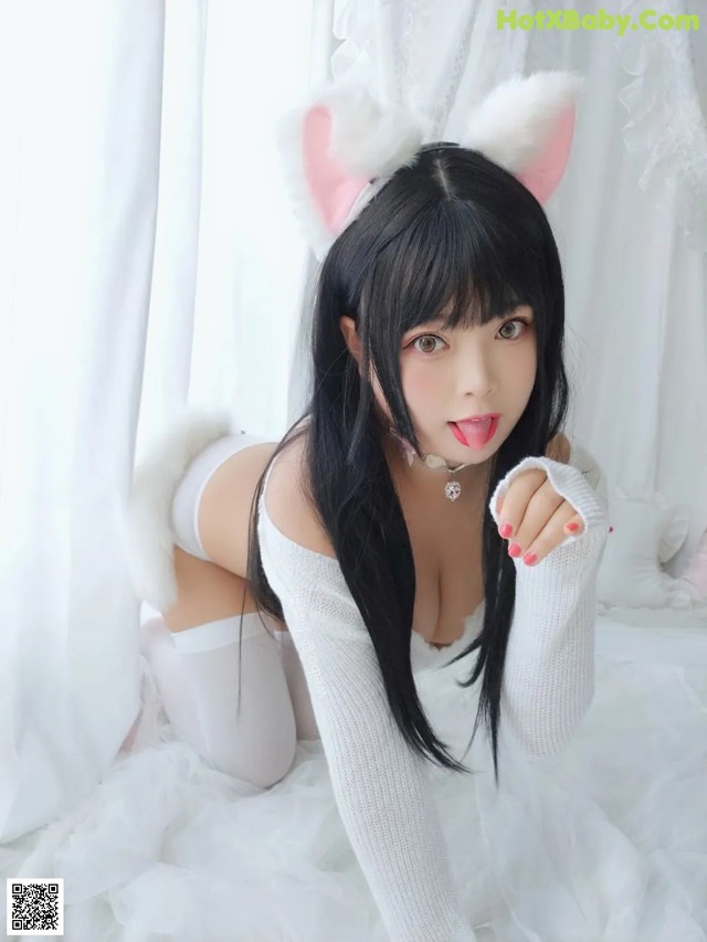 A woman in a white outfit with a cat ears on her head.