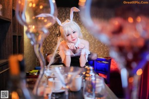 A woman dressed as a bunny holding a bottle of wine.