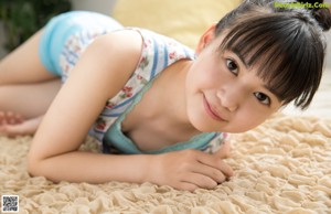 A young woman sitting on the floor smiling at the camera.