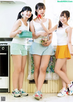 A couple of women standing next to each other in a kitchen.