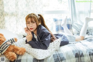 A woman sitting on a couch holding a teddy bear.