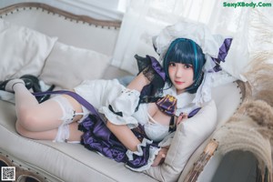 A woman in a maid outfit sitting on the floor.